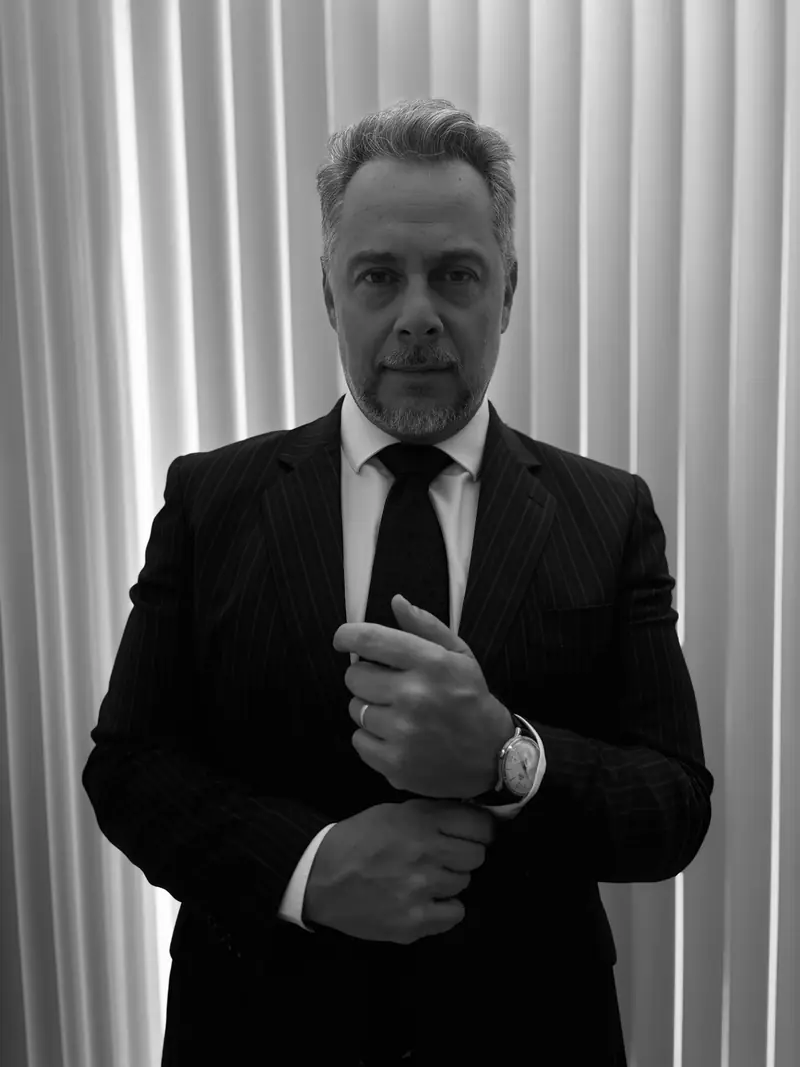 Leandro Corrêa de Oliveira, em preto e branco, diante de uma cortina